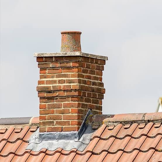 Brick chimney stack with lead flashing on tiled roof